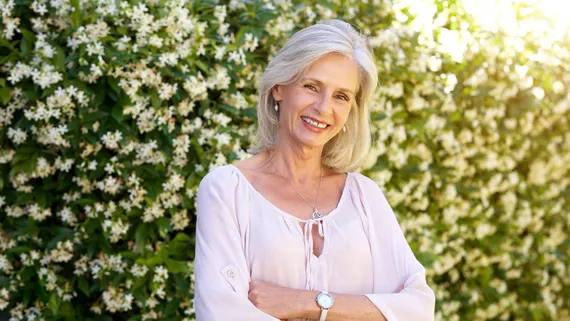 Smiling older woman standing in a garden